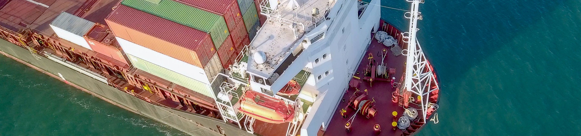 Large Cargo and RoRo (Roll On-Off) ship at sea, loaded with a small amount of shipping containers